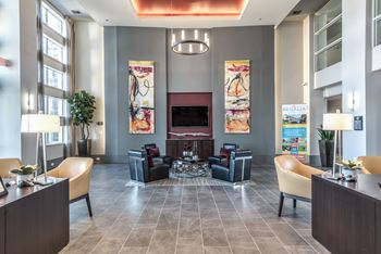 a lobby with couches and chairs and a fire place in the middle of the floor